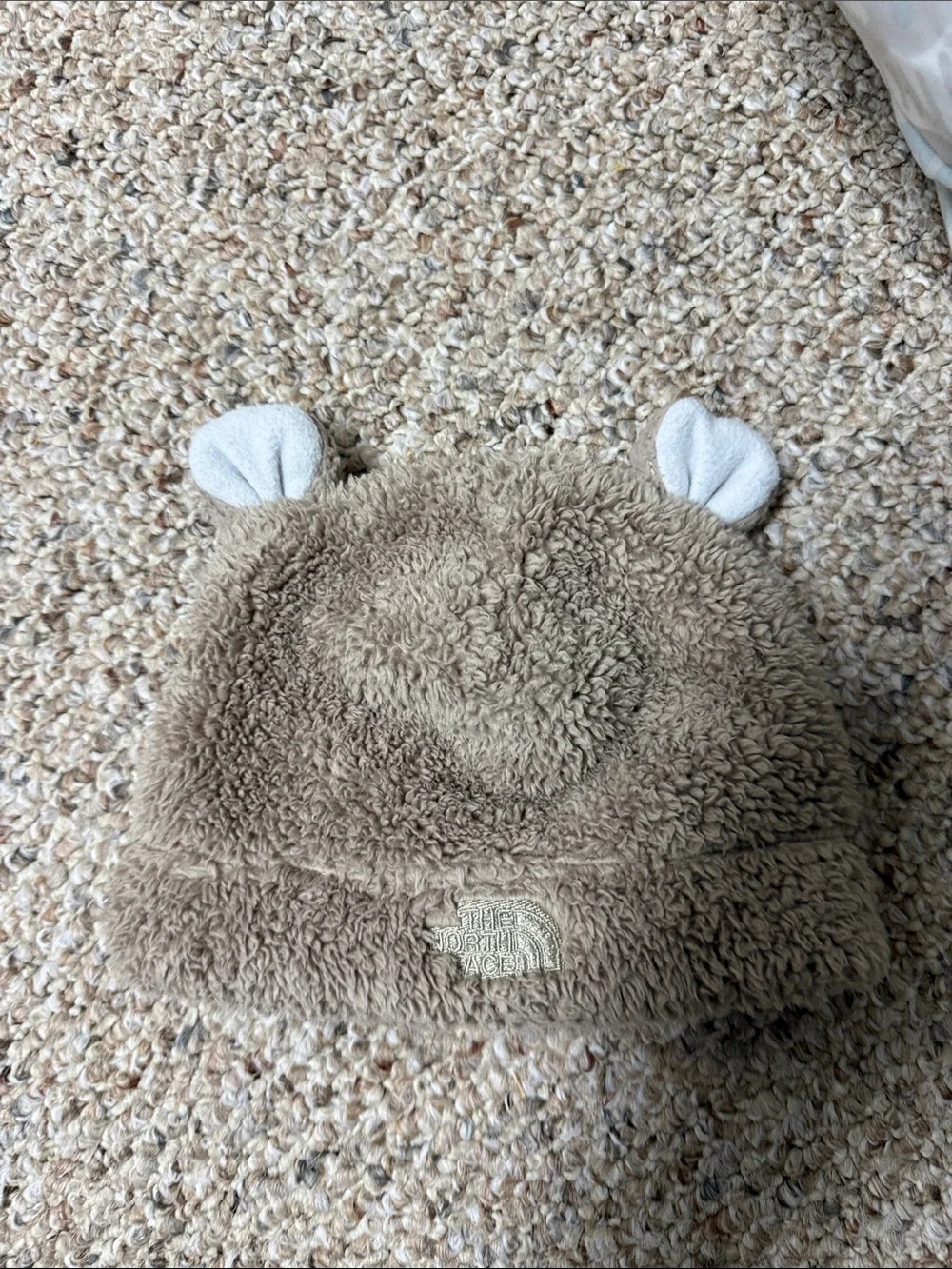 The North Face Kids Teddy Fleece Beanie Hat in Taupe with White Ear Accents. 3-6